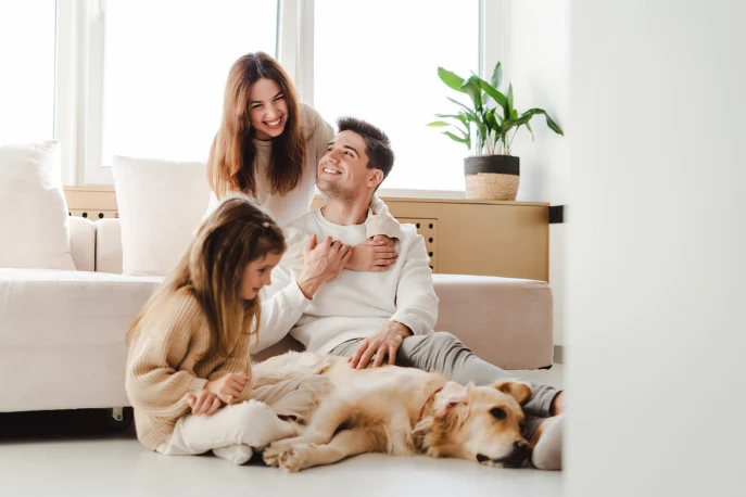 Family smiling in their home with their dog