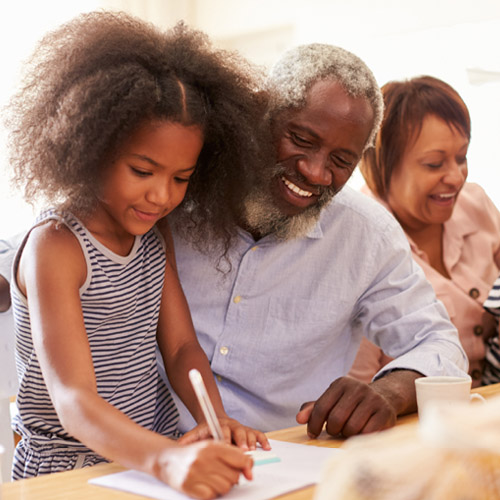 senior man helping his granddaughter with homework
