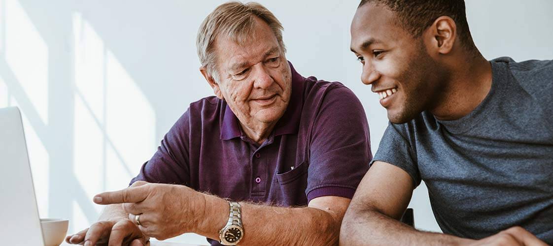 Young man and older man looking at computer